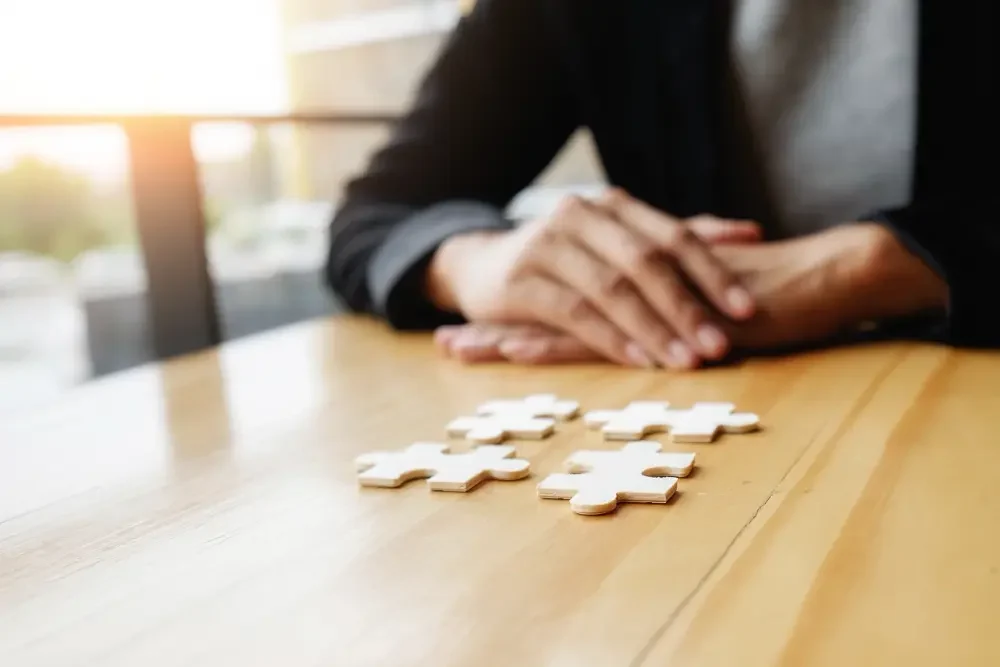 Grigorii Eremian sentado en la mesa delante de unas piezas el un puzzle